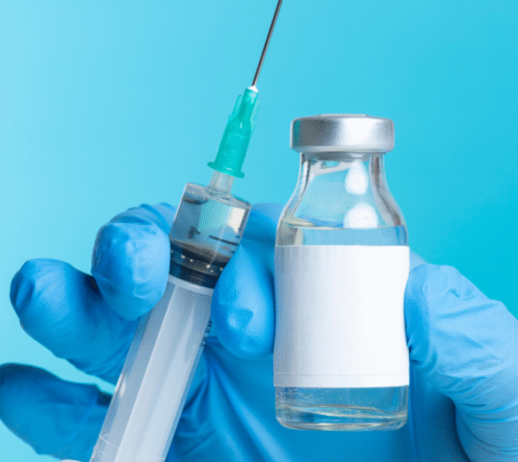 Hand met spuit en flesje met vaccinatiemiddel